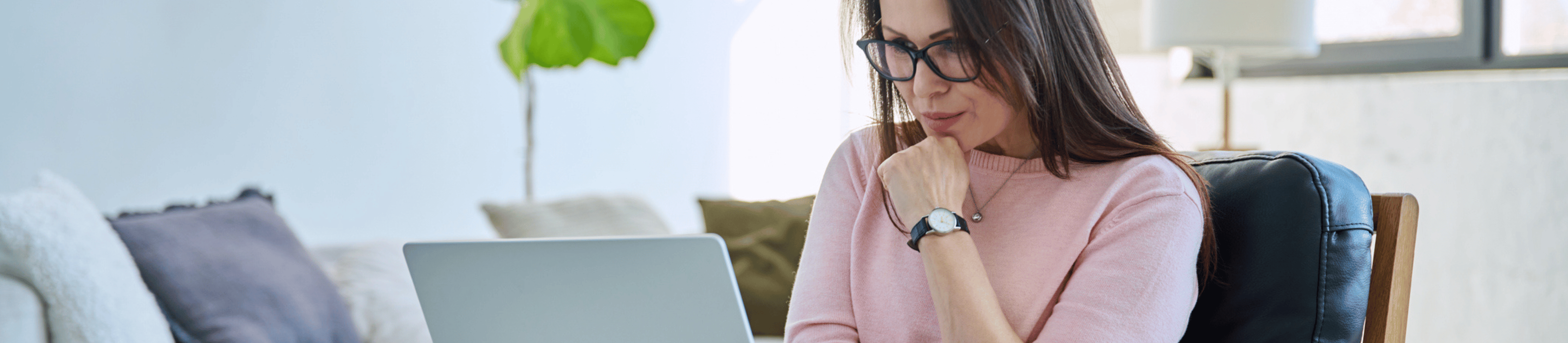 Thoughtful looking woman staring at laptop screen